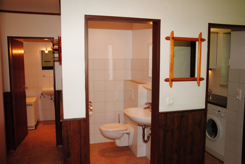 Flur:Ansicht auf Küche, WC und Bad. Einheitlicher Boden. Warme Terracotta Fliesen